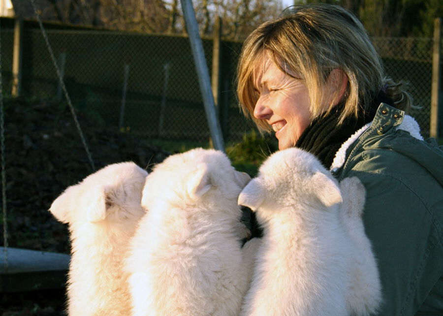 Tierärztin Sylke Rhein mit drei Welpen im Garten